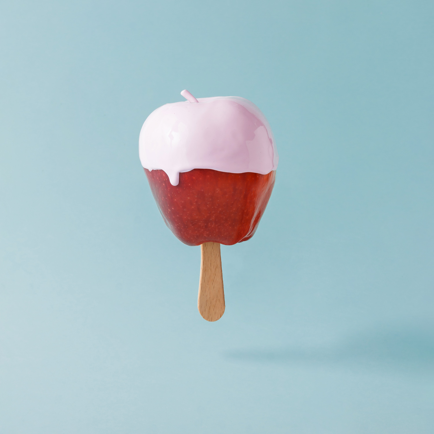 red-apple-with-ice-cream-stick-on-pastel-blue-back-2021-08-28-17-01-37-utc