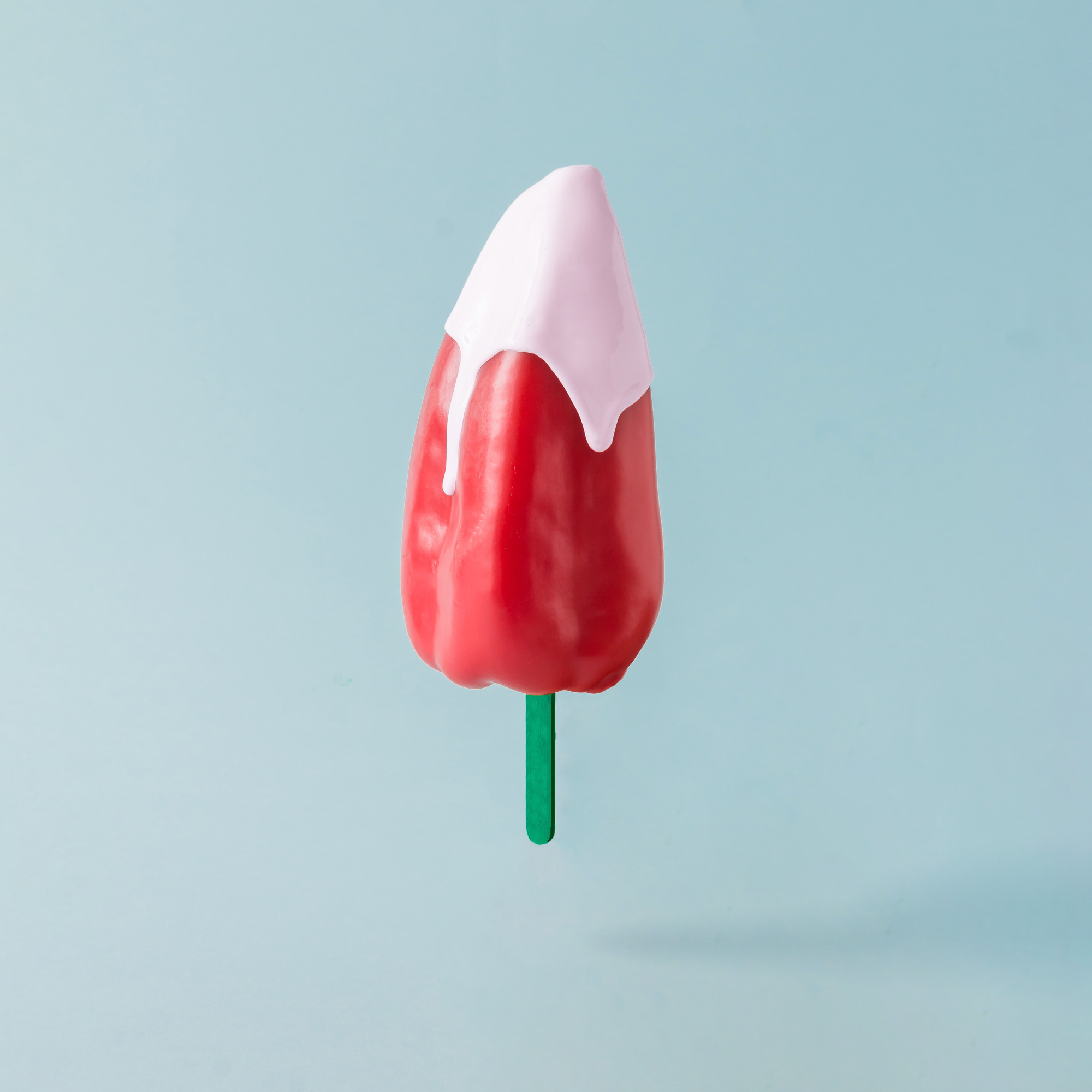 red-pepper-with-ice-cream-stick-on-pastel-blue-bac-2021-09-01-23-18-03-utc